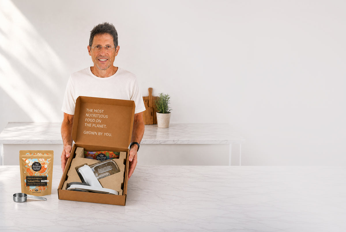 Man unboxing The Sprouting Company starter kit at a kitchen counter